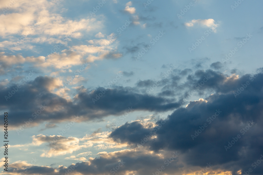 Blue sky at sunset with colorful clouds. Blue, yellow, white, gray and dark blue. Beautiful nature concept for design Blue sky at sunset with colorful clouds. Blue, yellow, white, gray and dark blue. Beautiful nature concept for design