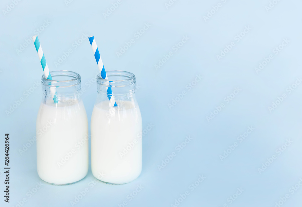 Bottle of fresh milk with straw on light blue background, food healthy concept Bottle of fresh milk with straw on light blue background, food healthy concept