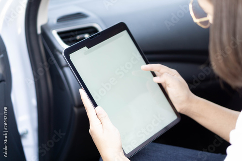 Closeup asian woman using digital tablet in a car