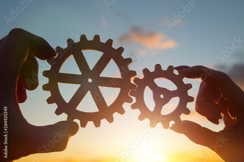 Tablou pe pânză hands of businessmen assemble gears into a puzzle mechanism