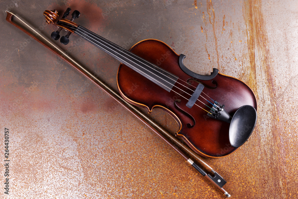 Fototapeta premium Classical violin on rusty background. Studio shot of old violin. Classical musical instrument