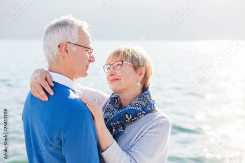 Happy senior couple at sea beach outdoor. Man and woman are hugging, embracing, enjoying retirement and life. Concept of wellbeing, happiness, male and female health, lifestyle moments. © Marina April