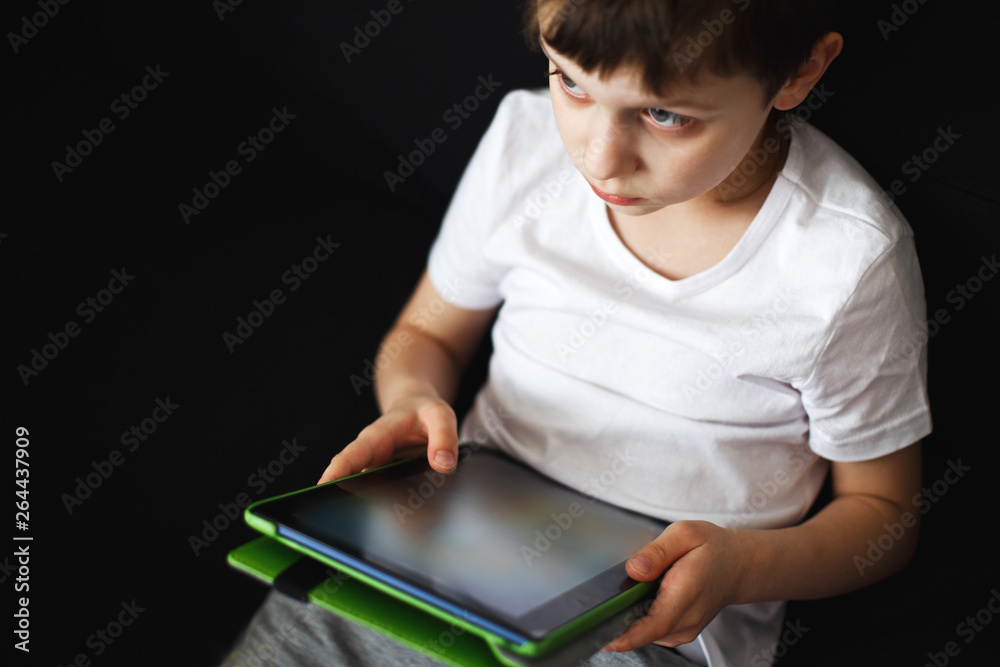 Fototapeta premium boy sits with a tablet in hand