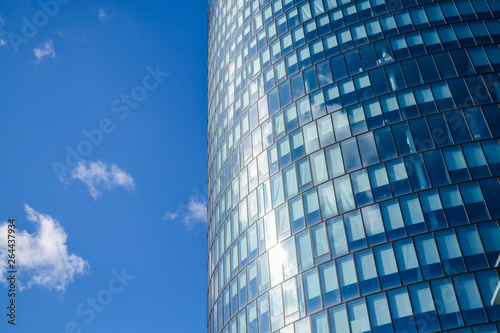 Modern architecture of office buildings. A skyscraper from glass and metal. Reflections in windows of blue sky. Business center.