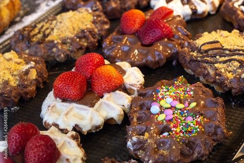 Waffles with whipped cream  strawberries  chocolate and candies