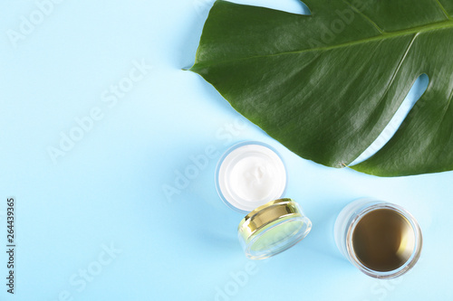 Moisturizing care skincare face cream for healing complicated troubled skin type in an open jar with visible texture. Copy space, close up, background, flat lay, top view. Monstera leaf decoration.