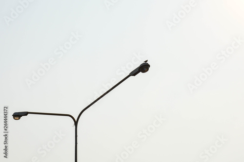 street lamp post isolated on pale sky background