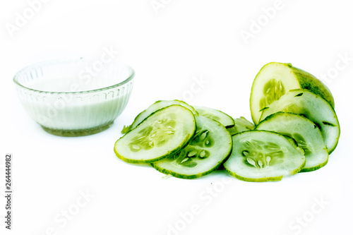 Cucumber face pack isolated on white i.e. Cucumber pulp well mixed with raw milk in a glass bowl and entire raw ingredients present on the surface.Used for the instant glow.