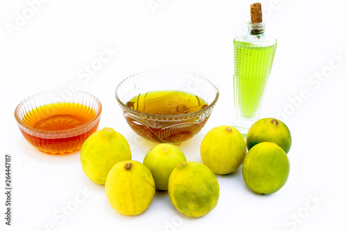 Lemon hair growth mask isolated on white i.e. Lemon juice well mixed with honey and Olive oil in a glass bowl with entire raw ingredients. photo