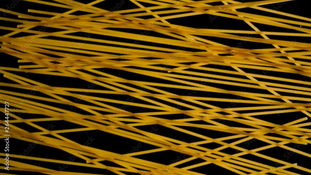 Close up of spaghetti pasta falling from darkness towards the ground with a black background