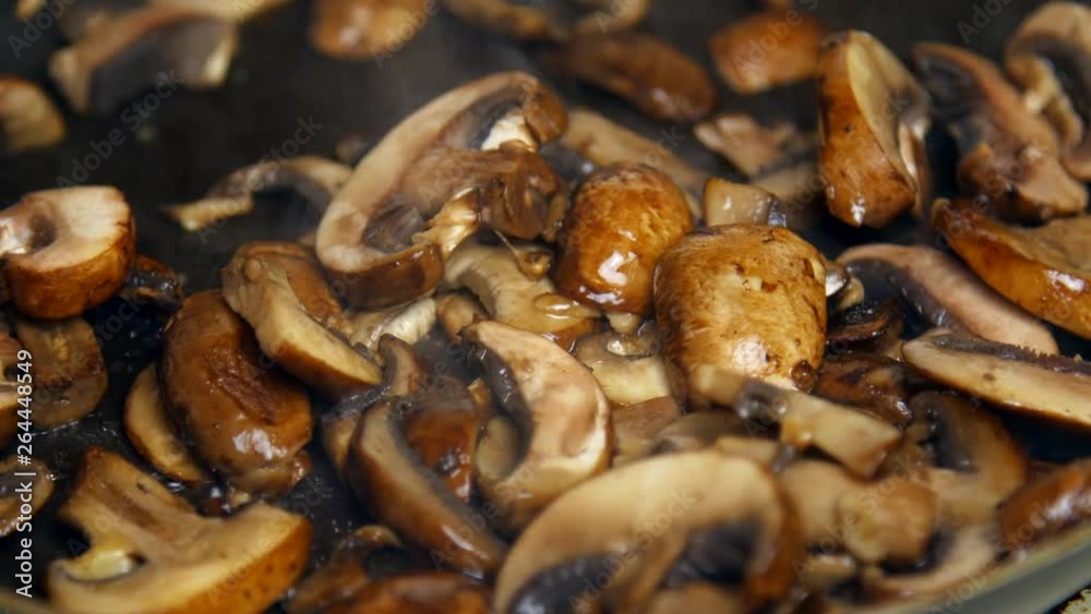 Sliced mushrooms cook in a pan. Sliced mushrooms cook in a pan.