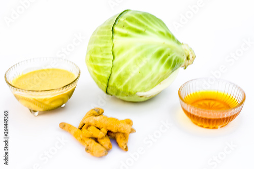 Cabbage face mask isolated on white consisting of cabbage juice well mixed with honey and turmeric in a glass bowl and entire raw ingredients present on the surface.Used to remove infections and tans.