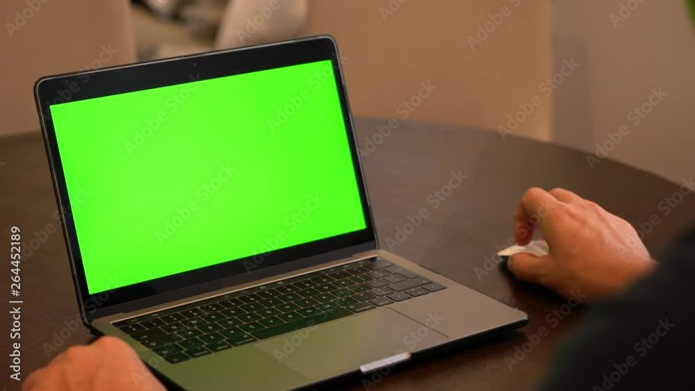 Over shoulder man using laptop with green screen. Over shoulder man using laptop with green screen.