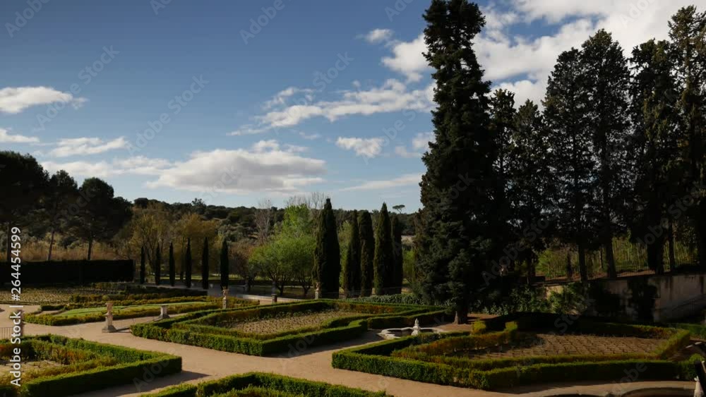 Static long shot of a baroque garden. With trees,hedges and a bird passin at the beginning of the shot