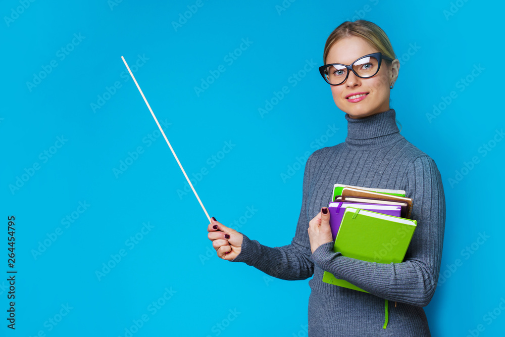 Photo of woman teacher with pointer and books in their hands Photo of woman teacher with pointer and books in their hands