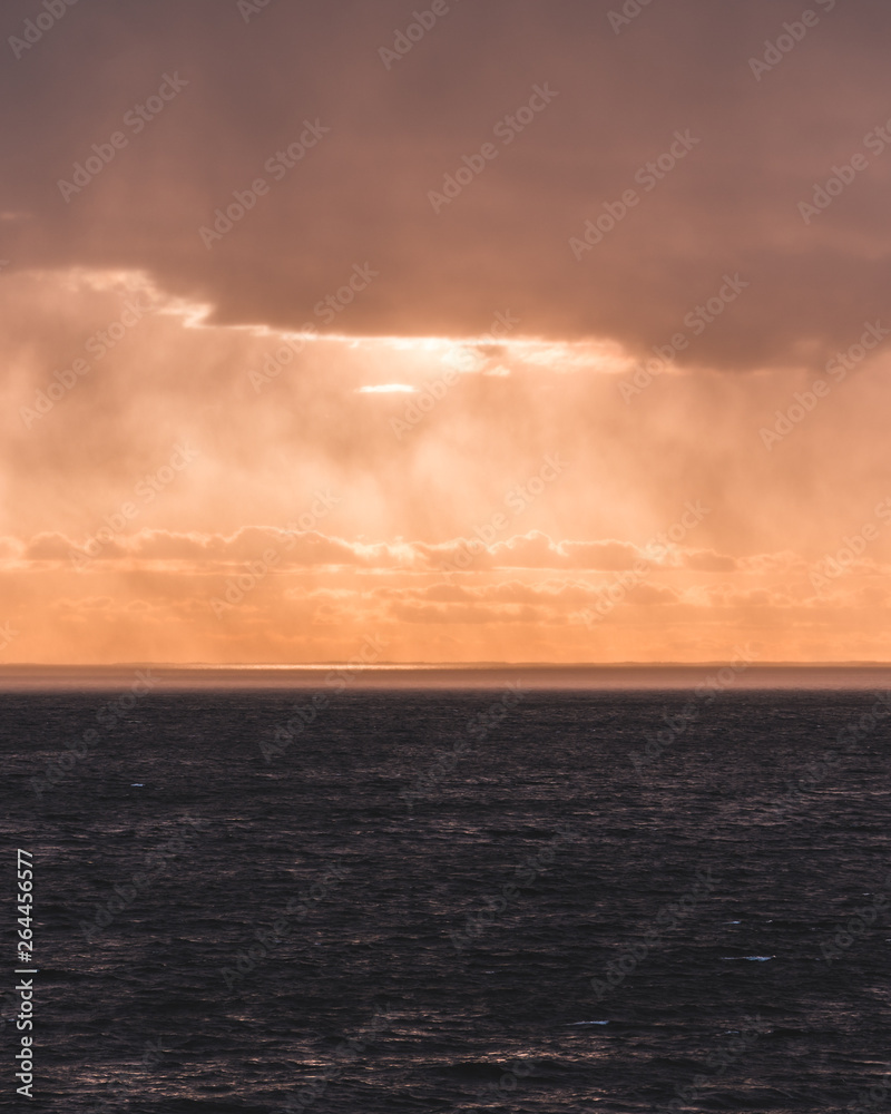 Sunset at sea with sunlight coming through the rain clouds, Finland Sunset at sea with sunlight coming through the rain clouds, Finland