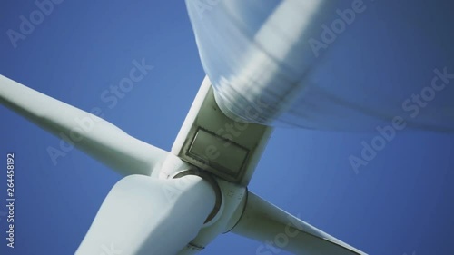 Afternoon underneath perspective and standing footage from a wind turbine machine and its rotating blades. photo