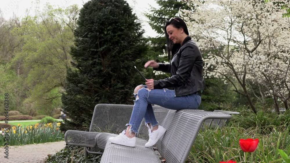 Brunette on a street bench with a tablet Brunette on a street bench with a tablet