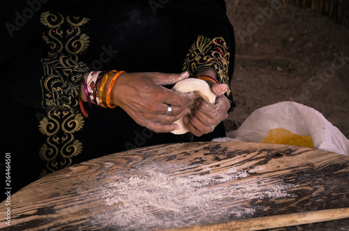 Female old hands with a test in their hands, a Muslim woman in traditional clothes prepares bread for the family