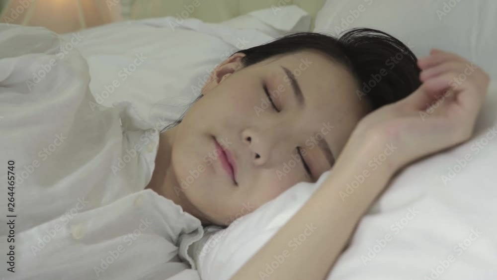 young asian woman sleeping in bed with white bedding young asian woman sleeping in bed with white bedding