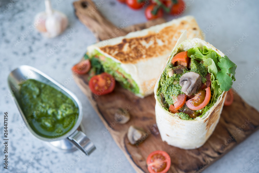 Burrito wraps with vegetables and sauce pesto.Roll with vegetables, mushrooms and pesto sauce. Vegetarian kebab. Of diet food.