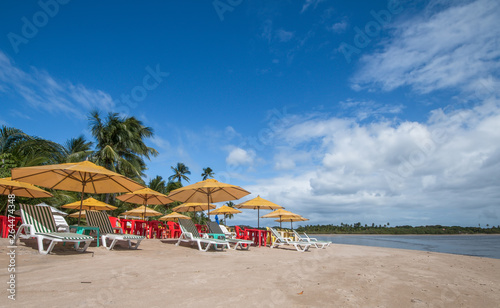 Beach chairs and umbrellas on tropical beach