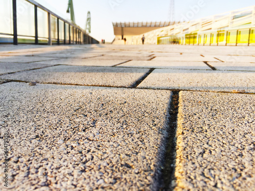 Stone, road tile close-up. In the background is the city in nefocus.