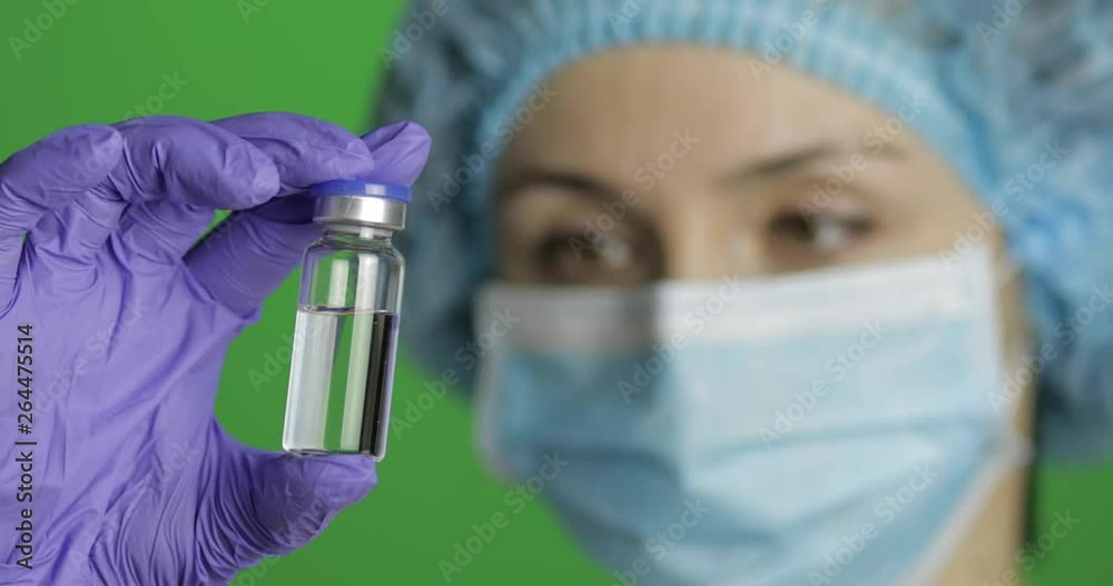 Female scientist holding ampoule in hand, new medication developing, vaccination Female scientist holding ampoule in hand, new medication developing, vaccination