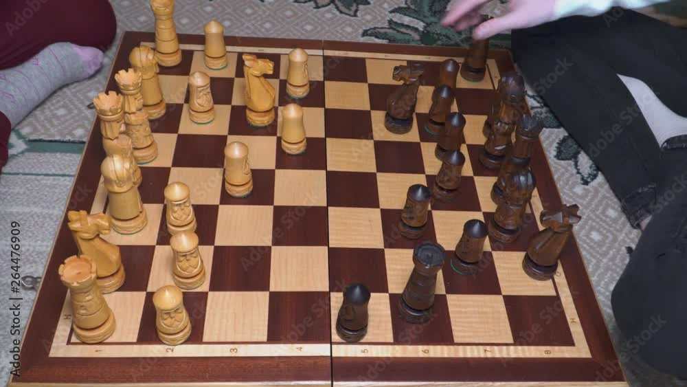 Two children playing chess on the chessboard Two children playing chess on the chessboard