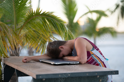 Young woman with laptop on beach