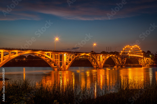 Bilde på lerret The bridge over the Arkansas River at Ozark Arkansas at dusk with the lights on