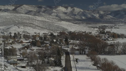 Aerial view of road and houses in valley near mountain range in winter / Wallsburg, Utah, United States photo