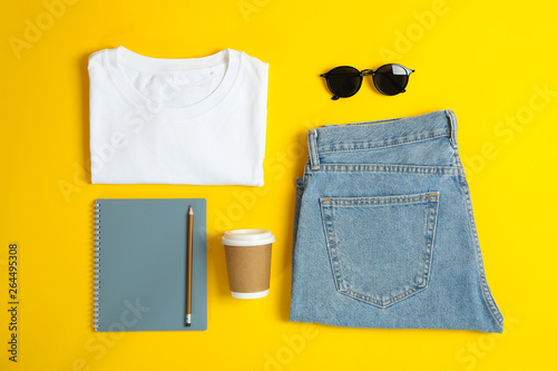 Flat lay composition with women clothes and creative accessories on yellow background. Inspiring backdrop