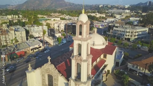 Aerial, descending, drone shot in front of St Charles Borromeo church, on a sunny day, in north Hollywood, Los angeles, California, USA photo