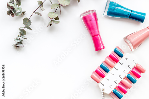 decorative cosmetics set with flowers, nail polish and palette for manicure on white background top view space for text