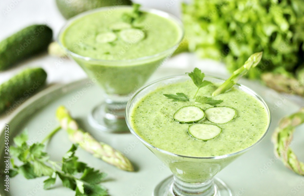 soup puree from avocado, asparagus and cucumber. Dietary detox diet. Vegetarian dish. serving soup in a glass bowl. soup puree from avocado, asparagus and cucumber. Dietary detox diet. Vegetarian dish. serving soup in a glass bowl.