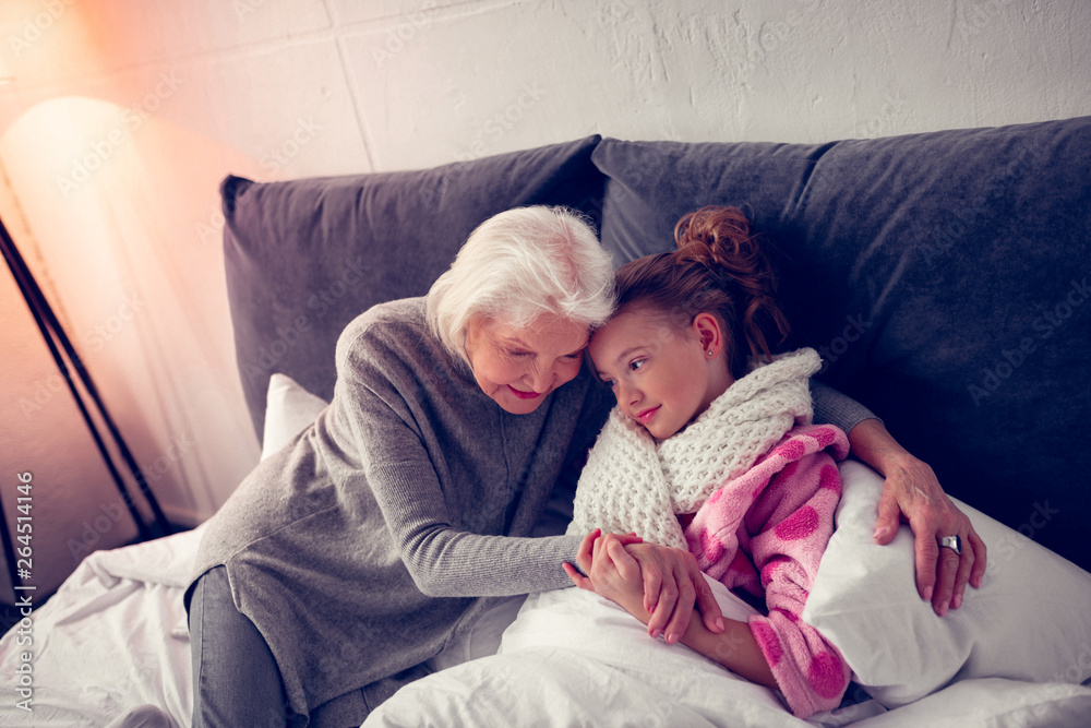 Sick girl feeling grateful while caring granny supporting her Sick girl feeling grateful while caring granny supporting her
