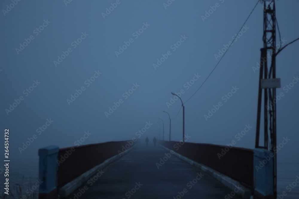 two silhouettes in the fog reaching over the bridge