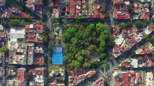 DRONE FLIGHT OVER PARK IN MEXICO CITY RESIDENTIAL AREA. KIDS PLAYGROUND COLORFUL, BLUE BASKETBALL COURT, AND CITY STABLISH photo