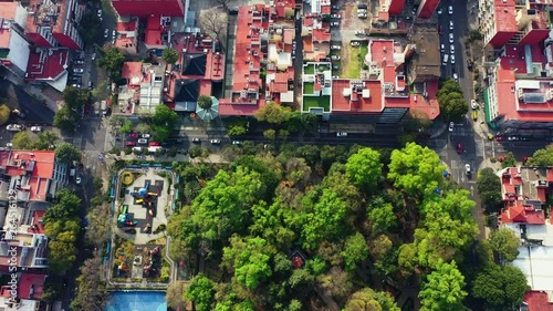 DRONE FLIGHT OVER PARK IN MEXICO CITY RESIDENTIAL AREA. KIDS PLAYGROUND COLORFUL, BLUE BASKETBALL COURT, AND CITY STABLISH photo