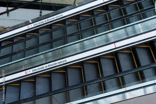 Dos escaleras eléctricas en primer plano con letrero en español que dice evite Circular en dirección contraria © @mpfotoproducto