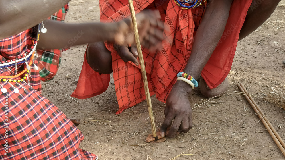 two maasai men use a hand drill to start a fire at a manyatta in kenya two maasai men use a hand drill to start a fire at a manyatta in kenya