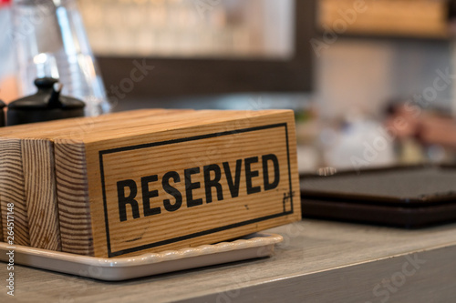 Reserved sign on top of a wooden table in a restaurant