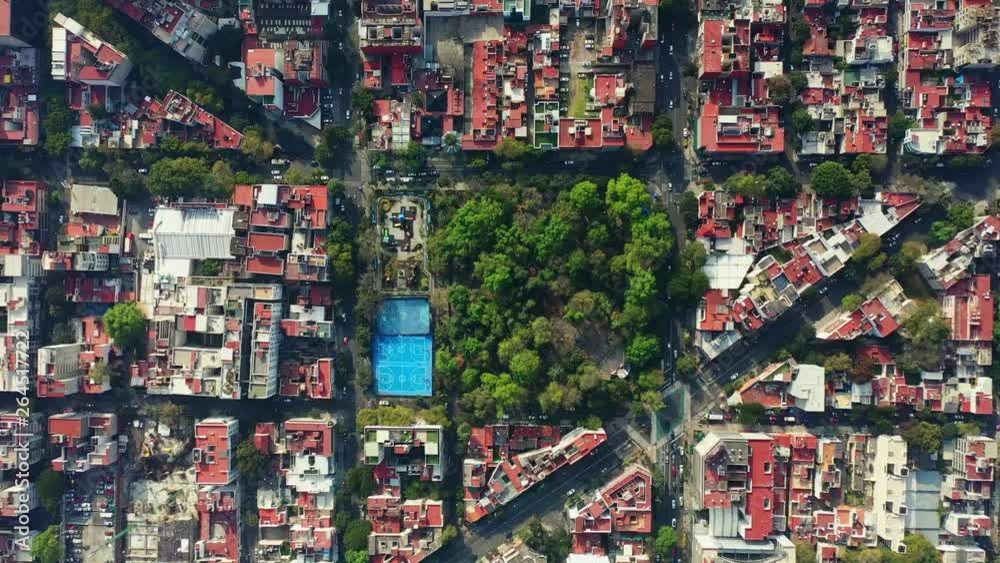 DRONE FLIGHT OVER PARK IN MEXICO CITY RESIDENTIAL AREA. KIDS PLAYGROUND COLORFUL, BLUE BASKETBALL COURT, AND CITY STABLISH DRONE FLIGHT OVER PARK IN MEXICO CITY RESIDENTIAL AREA. KIDS PLAYGROUND COLORFUL, BLUE BASKETBALL COURT, AND CITY STABLISH