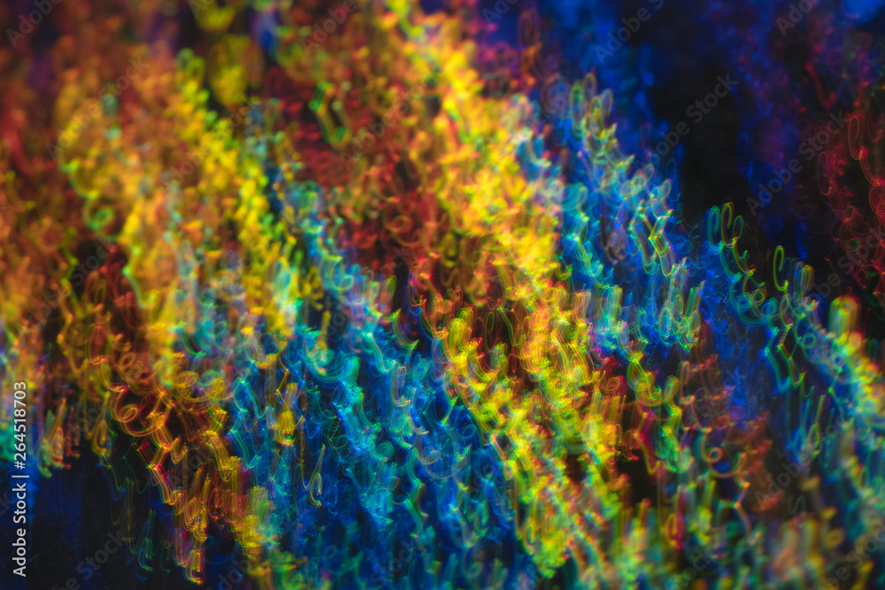 Defocused lights in motion. Swirled thin multicolor lines on dark background. Lens flare effect.