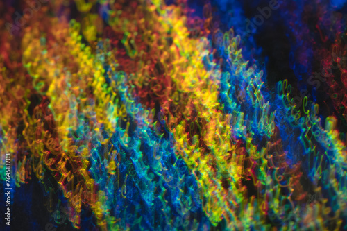 Defocused lights in motion. Swirled thin multicolor lines on dark background. Lens flare effect. © golubovy