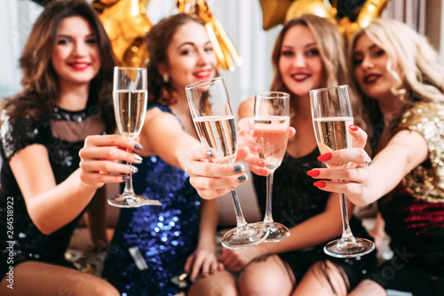Hen party. Girls holding glasses with champagne, congratulating friend with upcoming special day, happy for her.