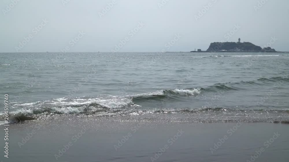湘南の浜辺 七里ヶ浜に打ち寄せる波と江ノ島の風景 湘南の浜辺 七里ヶ浜に打ち寄せる波と江ノ島の風景