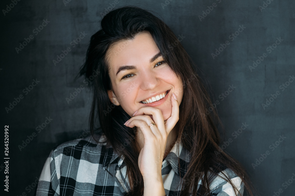Cheerful young woman portrait. Smiling beautiful brunette looking curiously. Hand at chin. Coquettish inquisitive lady. Cheerful young woman portrait. Smiling beautiful brunette looking curiously. Hand at chin. Coquettish inquisitive lady.