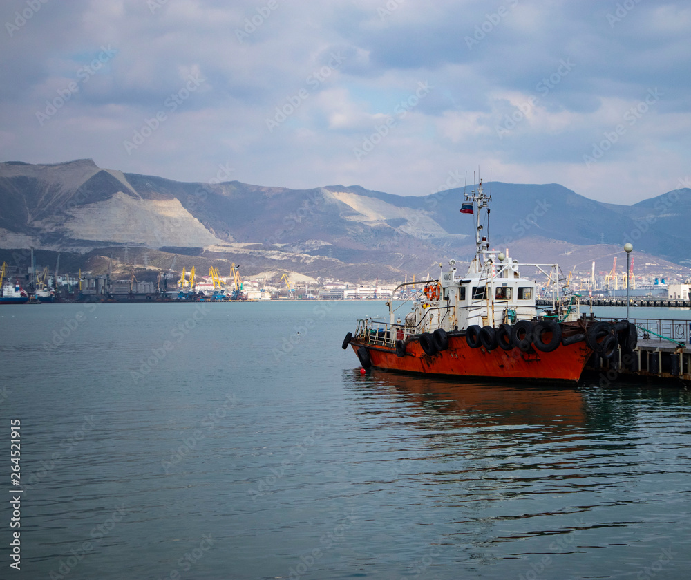 Fototapeta premium Amazing view on a harbor with great mountains behind the boat